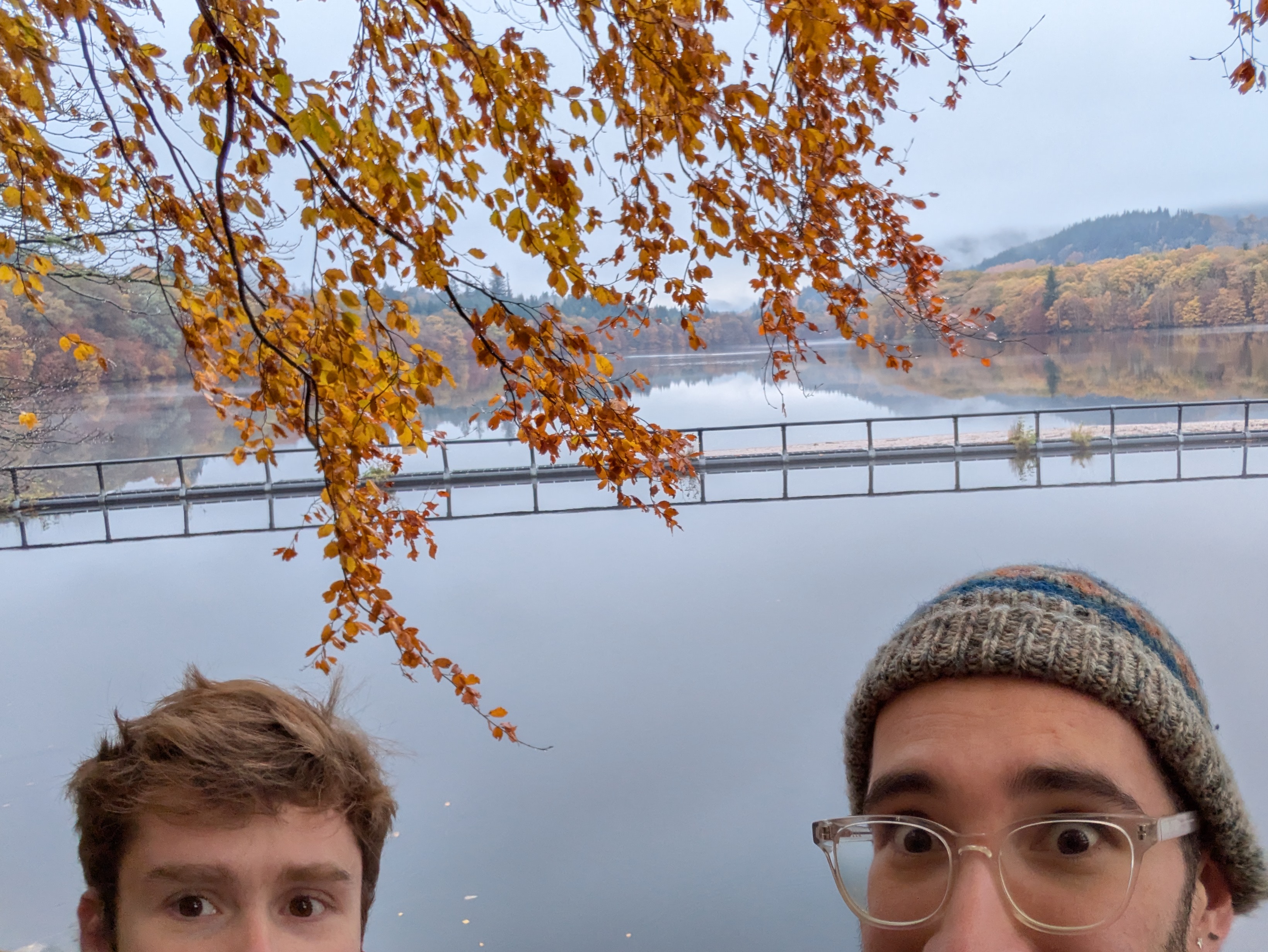 Jay and Leo looking concerned, mostly out of frame in front of a pretty nifty loch.